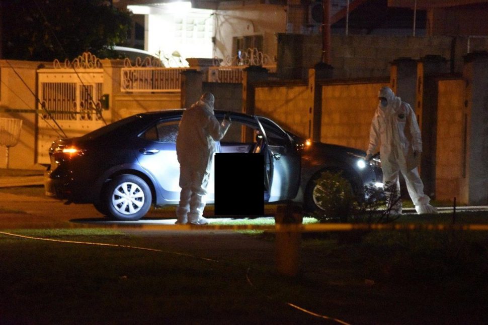 Murder scene: Forensic officers view the body of Superintendent Wayne Jackson outside his home in Malabar on Tuesday night.