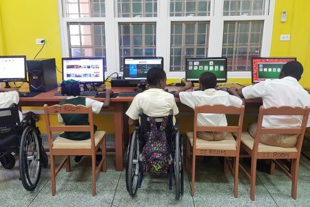 In photograph, students of the Ptolemy Reid Rehabilitation Centre utilising the donated smart lab.