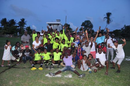 The victorious Soesdyke Falcons side posing with several of their supporters after defeating Grove Hi-Tech in the finale of the East Bank Football Association Year-end Qualifier Tournament,
