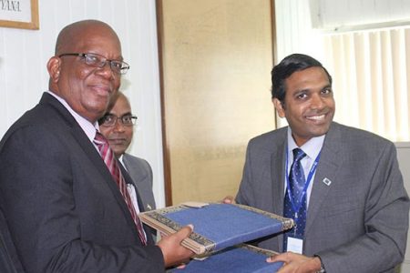 Minister of Finance Winston Jordan (left) and the Exim Bank Representative T.D. Sivakura exchanging documents after the signing for the Ogle to Diamond bypass road in March 2016.