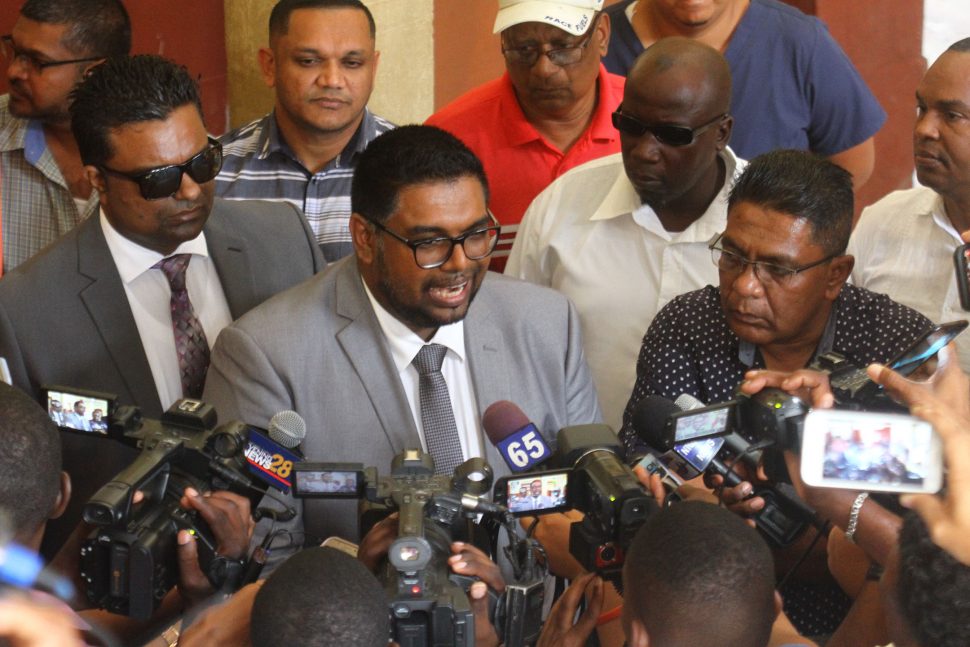 Irfaan Ali (centre) flanked by PPP/C supporters as he addressed members of the media outside of the courtroom.
