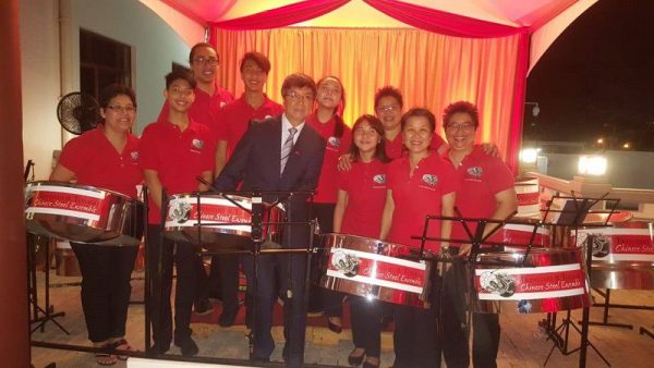 China's Ambassador to Trinidad and Tobago Song Yumin tries his hands at playing the steel pan, surrounded by members of the Trinidad and Tobago Chinese Steel Orchestra.