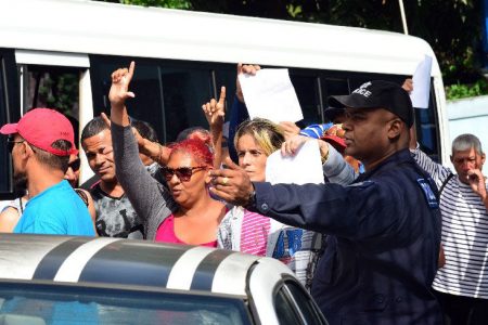 OFF TO COURT: Cuban refugees are escorted into a police maxi outside the Belmont Police Station yesterday before they were transported to the Port of Spain