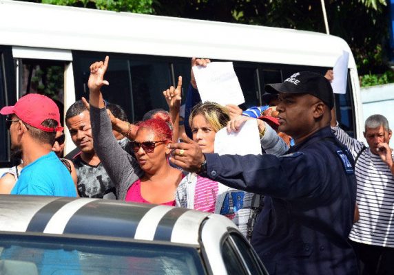 OFF TO COURT: Cuban refugees are escorted into a police maxi outside the Belmont Police Station yesterday before they were transported to the Port of Spain