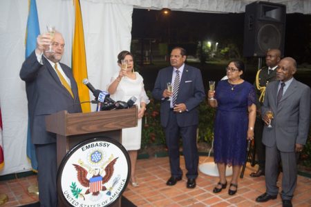 Outgoing US Ambassador Perry Holloway (left) speaking at the farewell reception hosted by the US Embassy on Friday evening. His wife Rosaura is second from left. Also in photo are Prime Minister Moses Nagamootoo (third, from right), his wife Sita (second, from right) and Foreign Affairs Minister Carl Greenidge (right). (Department of Public Information photo)
