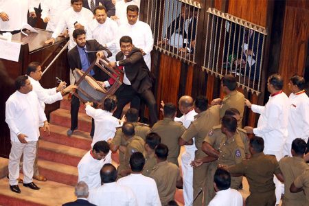 Parliament member Johnston Fernando who is backing newly appointed Prime Minister Mahinda Rajapaksa throws a chair at police who are there to protect parliament speaker Karu Jayasuriya (not pictured) during a parliament session in Colombo, Sri Lanka November 16, 2018. Photo: Reuters