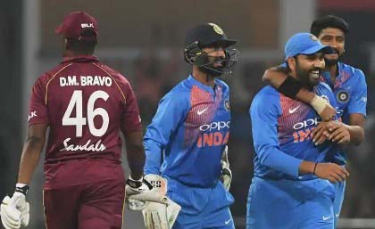 A disappointed Darren Bravo walks off as Indian fielders celebrate his dismissal in the second T20 International yesterday. 