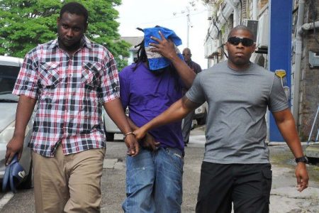 Cpl George ,right escorts Gregory James and Police Constable Shaundelle Euin to the San Fernando Magistrates' Court. They are charged for the kidnapping for ransom of Natalie Pollonais. 