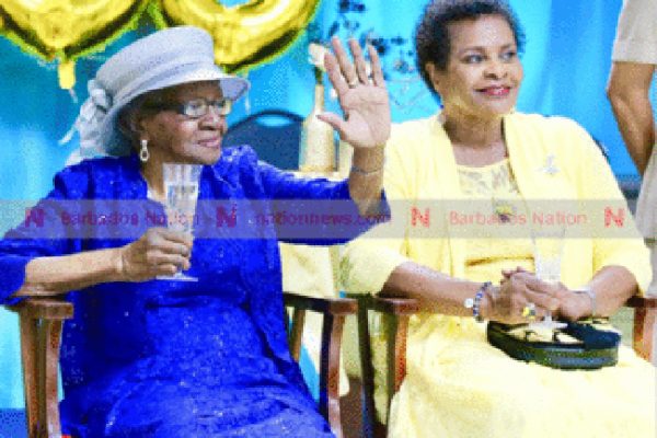 Governor General Dame Sandra Mason (right) looks on as centenarian Madeline Holder salutes one of her guests at yesterday’s birthday party. (Picture by Nigel Browne.)