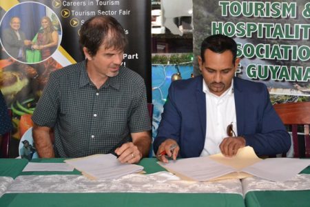 Director of GTA, Brian Mullis (left) and President of THAG, Mitra Ramkumar signing the MoU. (DPI photo)