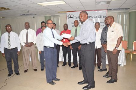 NBS CEO Anil Kishun (left) presents the sponsorship cheque to GCA President Roger Harper in the presence of NBS Directors and GCA officials.