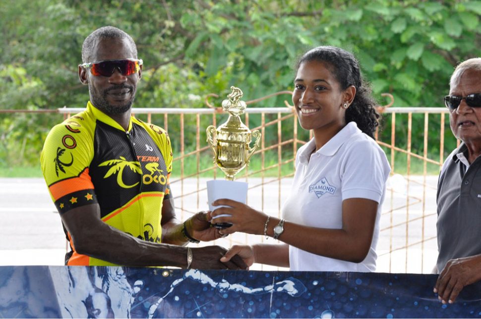Junior Niles receiving his prize from Diamond Mineral Water Assistant Marketing Manager, Sherese Leander

