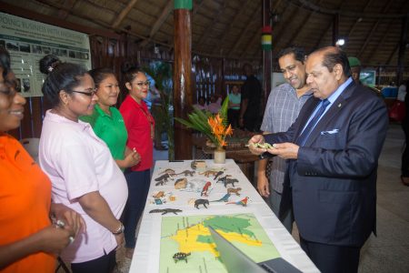 Prime Minister Moses Nagamootoo who is performing the functions of President visited the Iwokrama Open Day exhibition at the Umana Yana yesterday, the Department of Public Information (DPI) said. In this DPI photo,  the Prime Minister (right)  examines an animal figurine made from balata