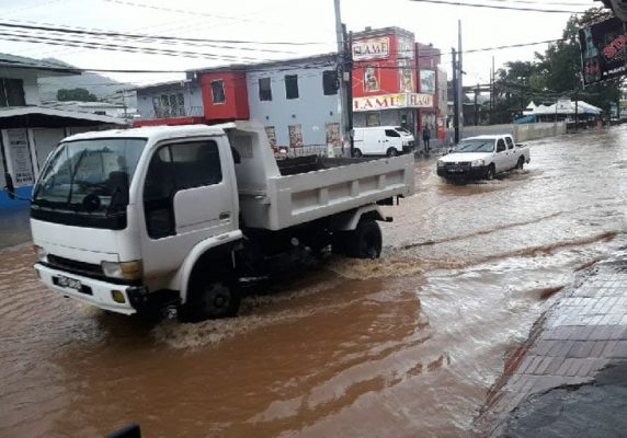 Slow going: Motorists drive through floodwaters on the Eastern Main Road, St Augustine, yesterday