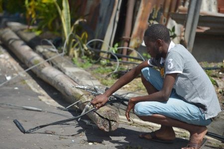 Mervin Seaton looks at utility pole which claimed the life of his friend Urlic John who died in a freak accident at his Rousillac home after the pole collapsed and killed him on Monday afternoon. 