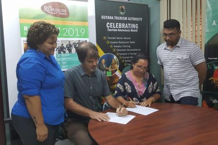 Visit Rupununi’s President Melanie McTurk signing the MoU on behalf of Visit Rupununi, while Brian Mullis signs for the Guyana Tourism Authority. (Photo from Visit Rupununi’s Facebook page)