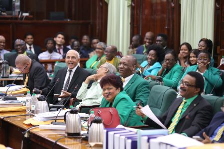  Government Parliamentarians scoff and heckle members of the opposition during Friday’s debate of the no confidence motion. (Photo by Terrence Thompson) 