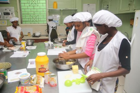 A few of the graduates preparing meals for their final assessment. (Photo by Terrence Thompson)
