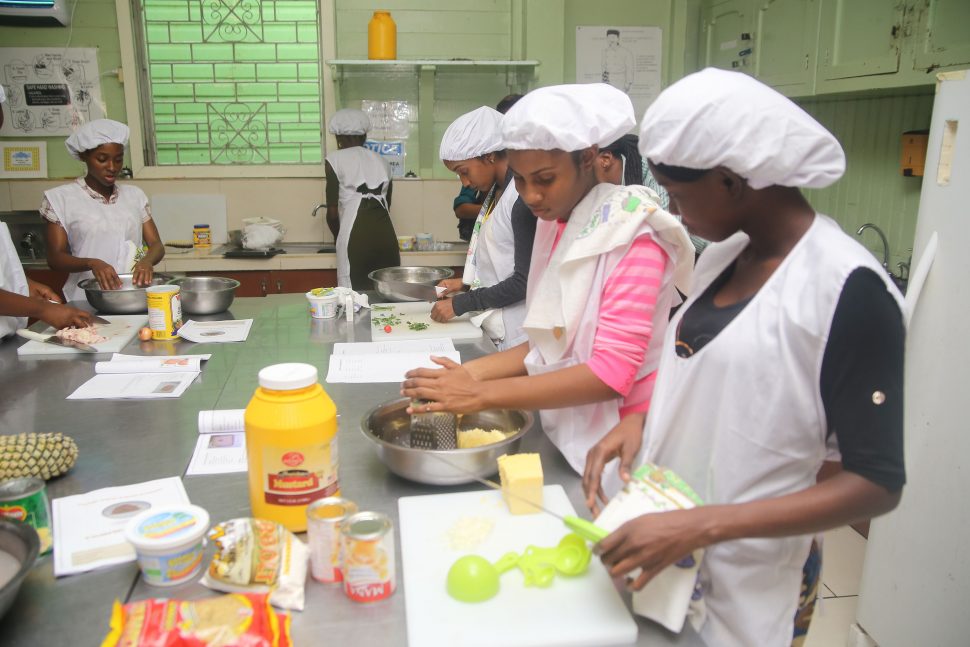 A few of the graduates preparing meals for their final assessment. (Photo by Terrence Thompson)
