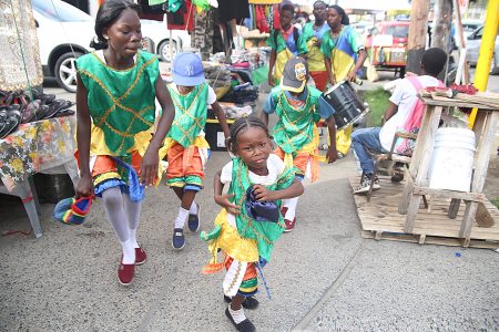 Festive masquerade: These masqueraders – young ones included – are keeping a Christmas tradition alive. They were enlivening the atmosphere on Camp Street yesterday. (Terrence Thompson photo)