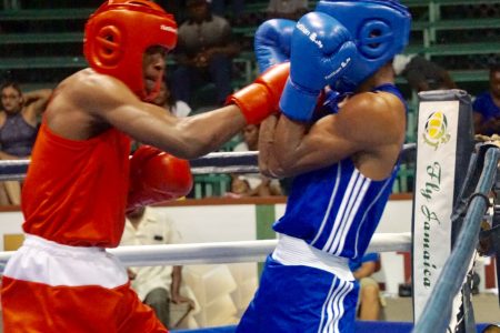 Guyana’s Kevin McKenzie (left) breaches the defense of Trinidad’s Jemell Joseph during their Caribbean Boxing Championship light welterweight bout last night at the Cliff Anderson Sports Hall. McKenzie won the novices’ fight on points. The four-day event concludes tonight. Bell time is set for 18:00hrs.