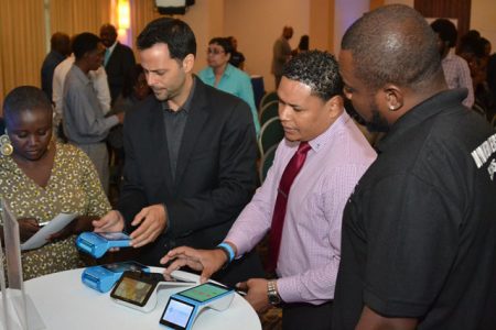Participants at launch of the WiPay app being shown a demonstration. (DPI photo)