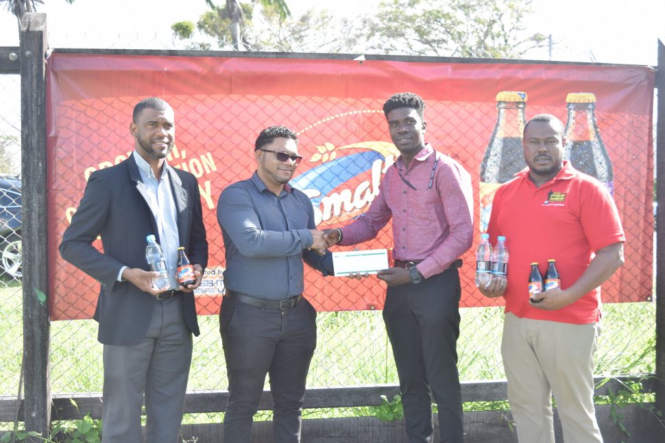 ANSA McAl’s Non-Alcoholic Brand Manager Errol Nelson (left) looks on as I-Cool Brand Manager Fharis Mohamed hands over a cheque to Mark Alleyne (2nd from right) of the Petra Organisation. Also in the   photo is Petra’s Co-Director Troy Mendonca,