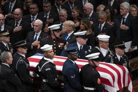 The flag-draped casket of former President George H.W. Bush is carried by a military honor guard past former President George W. Bush and wife Laura Bush, President Donald Trump, first lady Melania Trump, former President Barack Obama, Michelle Obama, former President Bill Clinton, former Secretary of State Hillary Clinton and former President Jimmy Carter during a State Funeral at the National Cathedral on Dec. 5, 2018, in Washington.
