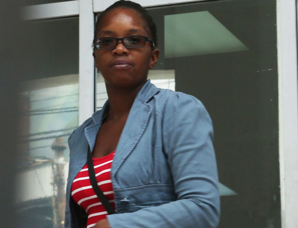 Mandisa Stewart leaves the Port-of-Spain Magistrates’ Court yesterday, after appearing on fraud charges involving flood relief cheque distribution.