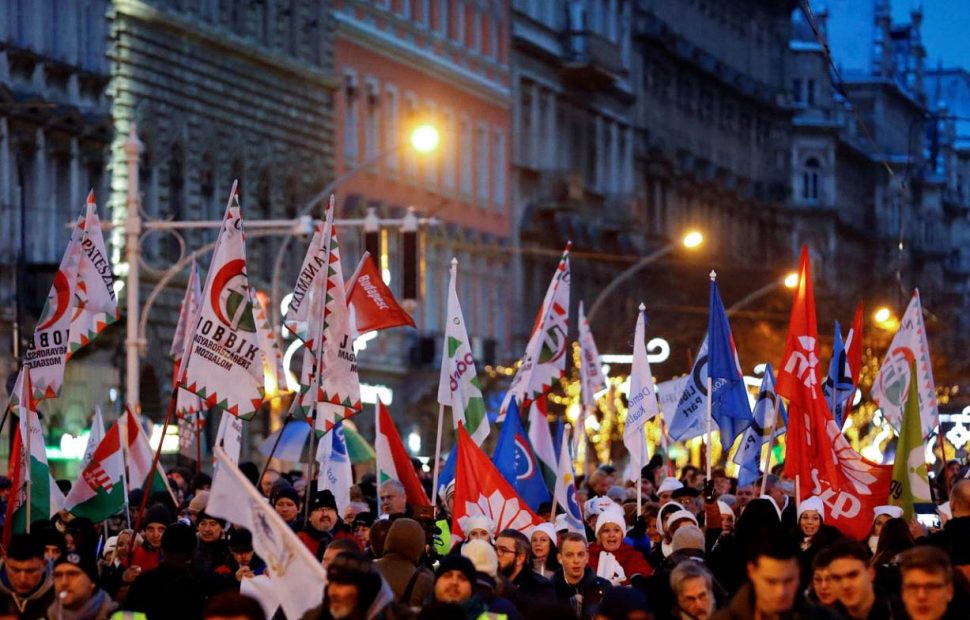 People walk with flags during a protest against a proposed new labor law, billed as the “slave law” in Budapest, Hungary, December 16, 2018. REUTERS/Leonhard Foeger
