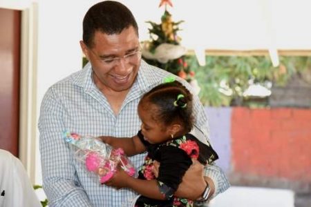 Prime Minister Andrew Holness, plays with young Mustard Seed Communities resident, Daniellia Wright, during his visit to the facility in his West Central St. Andrew constituency on December 28