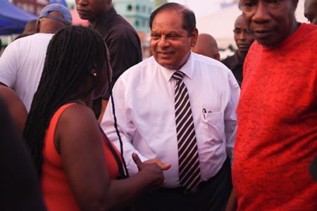 Prime Minister, Moses Nagamootoo (centre) meeting citizens  on Christmas  Eve at Stabroek Square. (DPI photo)