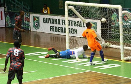 Raphael Lopes [orange/right] scoring the opening goal against the East Coast All-Stars Friday night at the Cliff Anderson Sports Hall, Homestretch Avenue in the ExxonMobil International Futsal Festival.