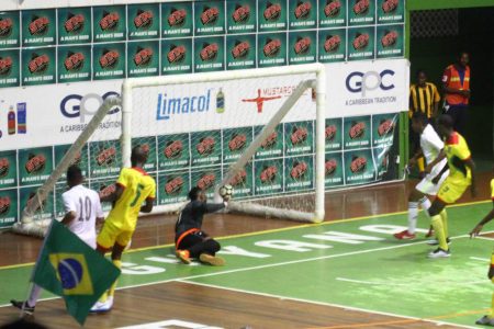 Arckson Andreazza [left] of Roraima Galacticos scoring his side’s opening goal against Team Guyana in the clash of the unbeaten sides in the ExxonMobil International Futsal festival at the Cliff Anderson Sports Hall.
