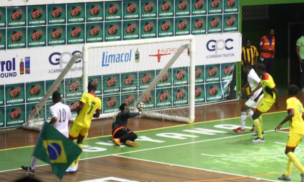 Arckson Andreazza [left] of Roraima Galacticos scoring his side’s opening goal against Team Guyana in the clash of the unbeaten sides in the ExxonMobil International Futsal festival at the Cliff Anderson Sports Hall.