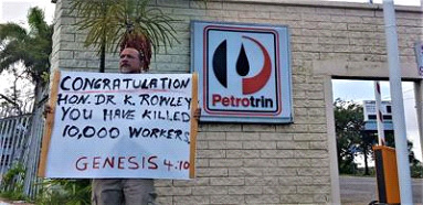 A former Petrotrin workers speaks for his colleagues with this sign outside Petrotrin’s refinery compound on Friday. 