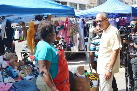 In this DPI photo, Minister of Business Dominic Gaskin (right) interacts with a vendor.