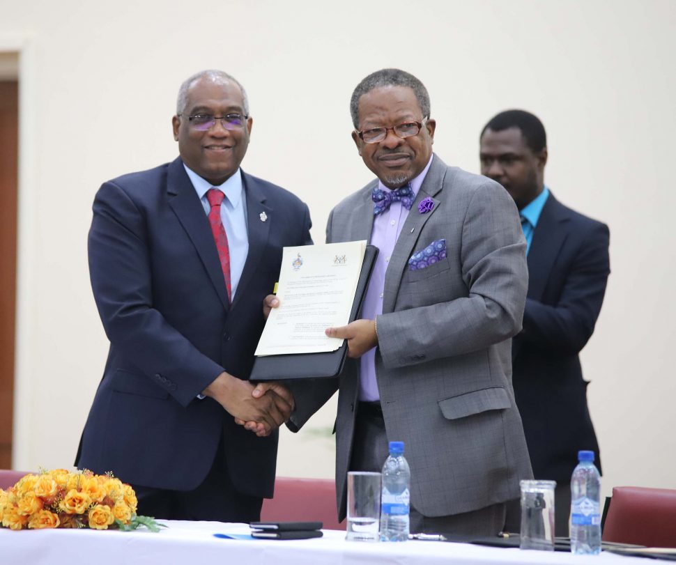 Professor Brian Copeland and Professor Ivelaw Griffith display the Memorandum of Understanding between the University of the West Indies and the University of Guyana to administer a Master’s of Science Degree in Petroleum Engineering. (Photo by Terrence Thompson)