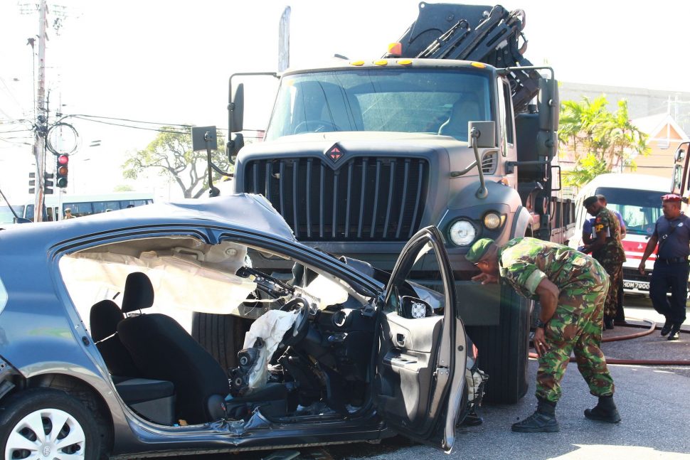 A soldier looks at the wrecked army truck which was involved in an accident at the intersection of the Priority Bus Route and Pasea Main Road, Tunapuna, yesterday.