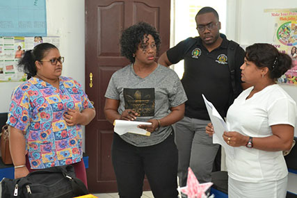 Dr. Kay Shako (second from left) and Dr. Horace Cox (second from right) interact with staff of the Agatash Health Post. (DPI photo)