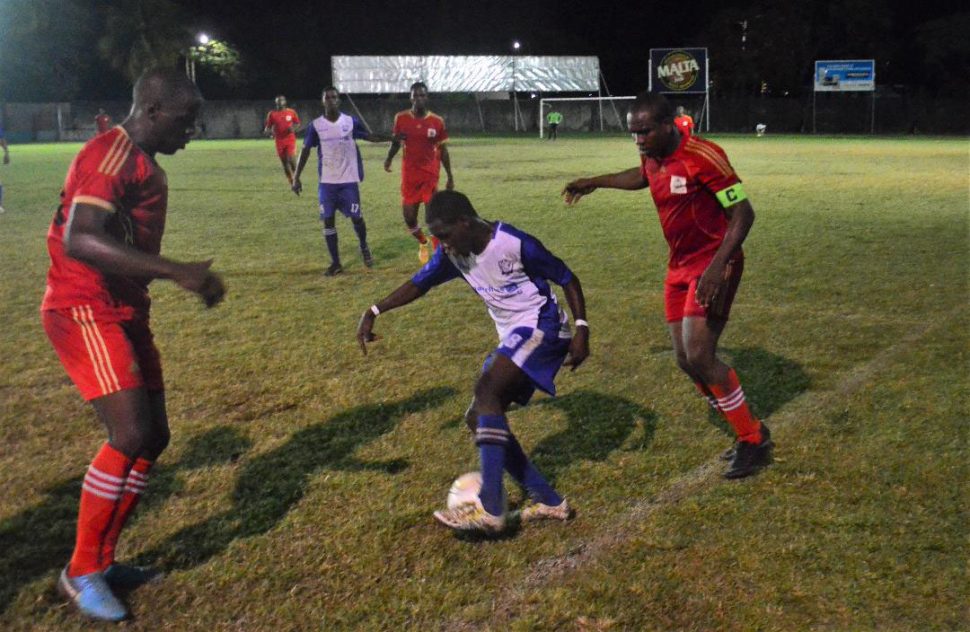 Lennox Cort [centre] of GFC trying to maintain possession of the ball while being challenged by two GPF players in the GFA ‘Revival Cup’ finale at the GFC ground, Bourda.