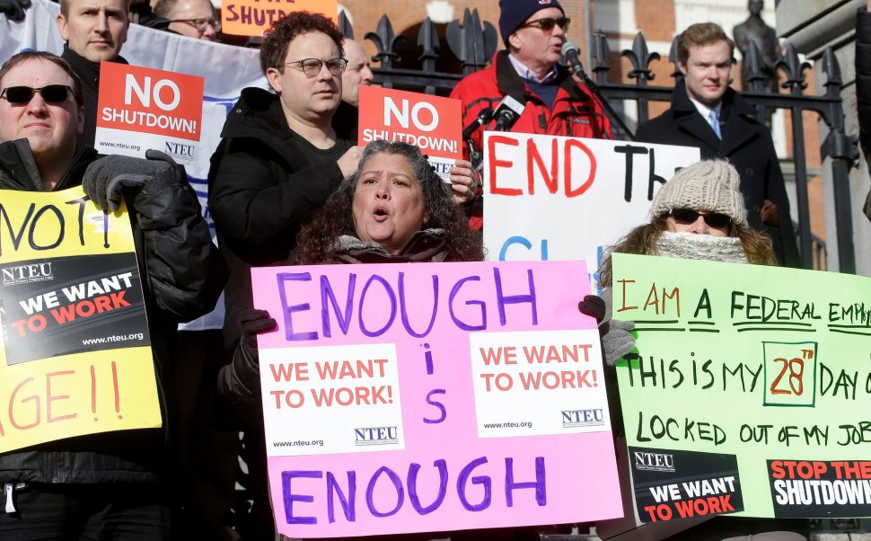 Internal Revenue Service employees display placards during a rally by federal employees and supports in front of the Statehouse, in Boston, to call for an end of the partial shutdown of the federal government.