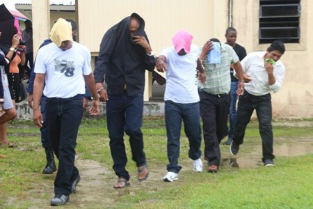 From left in handcuffs are Doodnauth Chattergoon, Rajendra Persaud, Khemraj Lall, Marlon Lawrence and Cleve Thornhill after they appeared in court on June 12
