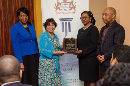 Director of the Jurist Project Gloria Richards-Johnson (left) and Canada’s High Commissioner to Guyana Lilian Chatterjee (second from left) handing over a plaque to Chancellor of the Judiciary (ag) Yonette Cummings – Edwards. Also, in the photo is CEO of Collins Ijoma and Associates, Collins Ijoma. (DPI photo)
