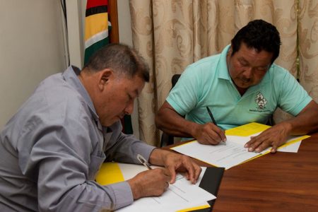 Minister of Indigenous Peoples’ Affairs Sydney Allicock (left) and Amerindian Peoples Association (APA), President, Mario Hastings signing the MOU. (DPI photo)