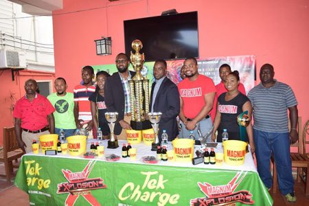 Tournament coordinator Esan Griffith collecting the championship trophy from Director of Sports Christopher Jones following the launch of the 2nd Annual Magnum Mash Futsal Championship yesterday at the Windjammer Hotel, Kitty. Also in the photo are representatives of Ansa McAl and players from several competing teams.