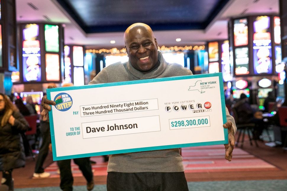 Dave Johnson, originally from Jamaica,  displays his Giants Powerball check for $298.3 million Friday at the Resorts World Casino in Queens.
