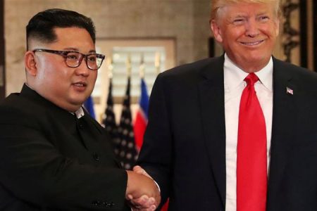 US President Donald Trump and North Korea’s leader Kim Jong Un shake hands after signing documents
