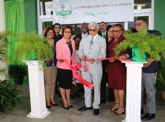 Minister of Health Terrence Deyalsingh, assisted by MP Toco/Sangre Grande Glenda Jennings-Smith, cuts the ribbon to officially open the Sangre Grande Enhanced Health Centre at Ojoe Road, Sangre Grande, yesterday.