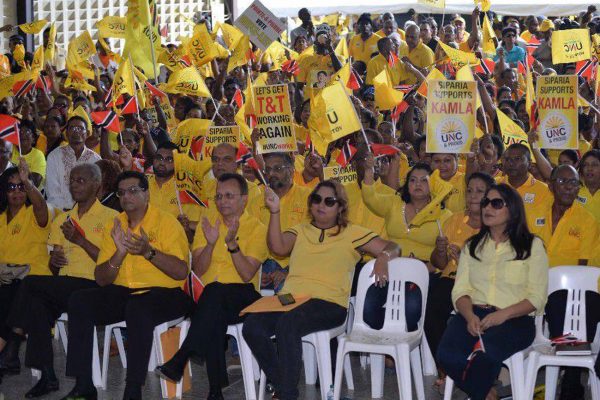 Supporters wave flags during the United National Congress (UNC) National assembly in Couva yesterday. -Photo: DEXTER PHILIP